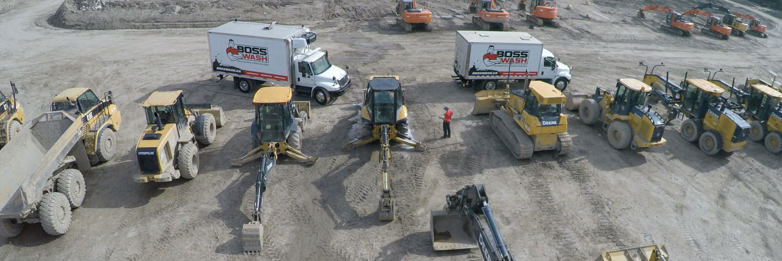 large yard of industrial equipment and the BOSSWASH pressure washer trucks